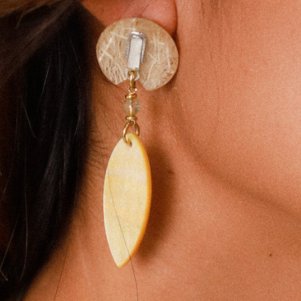 Image of circular woven earrings with golden mother of pearl surfboard shape dangle.